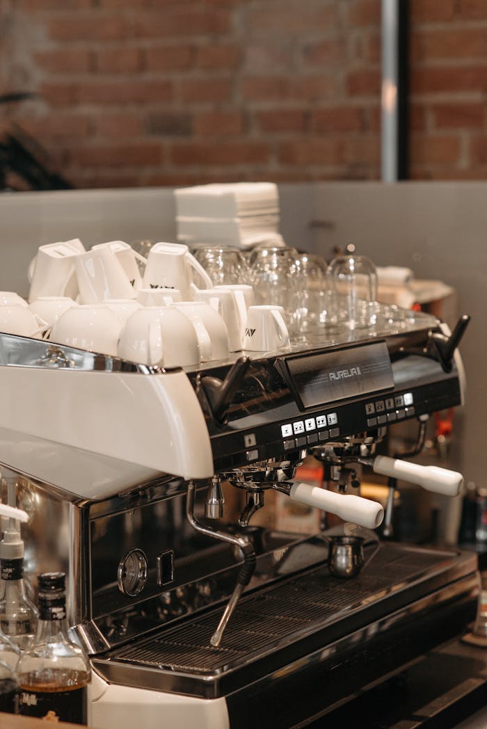 Close-up of a professional espresso machine with cups in a modern cafe setting.